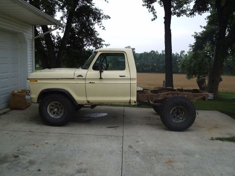 1979 Ford F-150 - Side view of a 1979 Ford F-150 pickup truck chassis, parked next to a garage.