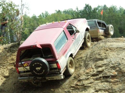 1995 Ford Bronco - Two off-road vehicles navigate a steep, rocky incline.