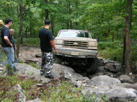 1995 Ford Bronco - Ford Bronco attempts to clear large rocks on an off-road trail.