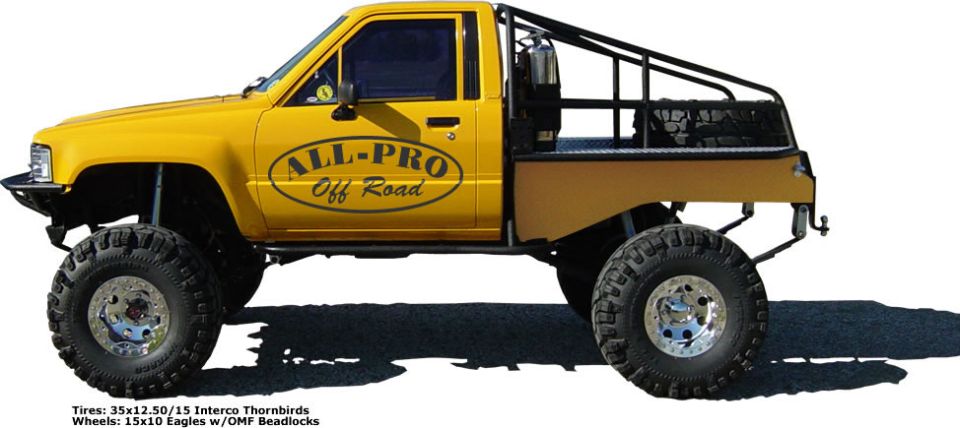 Yellow pickup truck with "ALL-PRO Off Road" decal on door, custom bed, and large tires