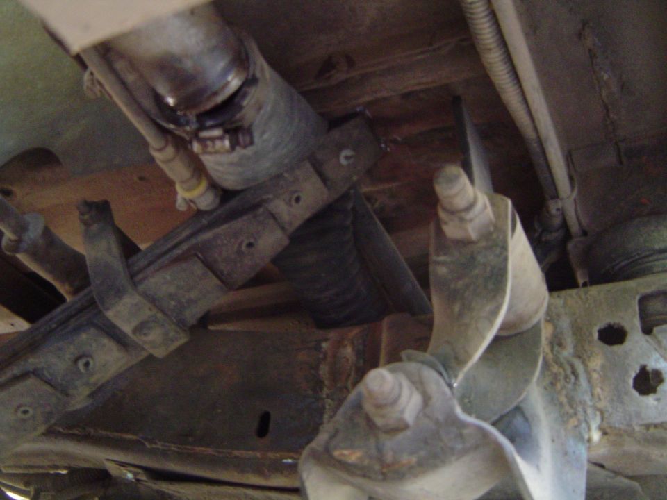 Underbody view of axle, frame crossmember and U-bolt plate with surface rust
