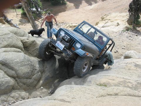 1982 Ford Customline - A man and his dog watch as a Jeep navigates a rocky off-road trail.