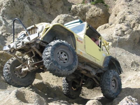 1982 Ford Customline - Modified Jeep CJ-7 tackling a rocky trail with large off-road tires.
