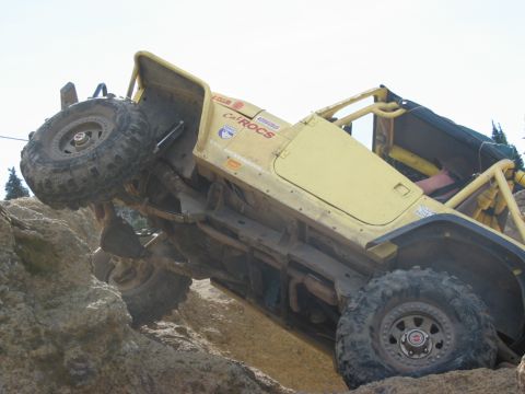 1982 Ford Customline - A yellow off-road vehicle navigates a rocky incline, demonstrating its off-road capabilities.