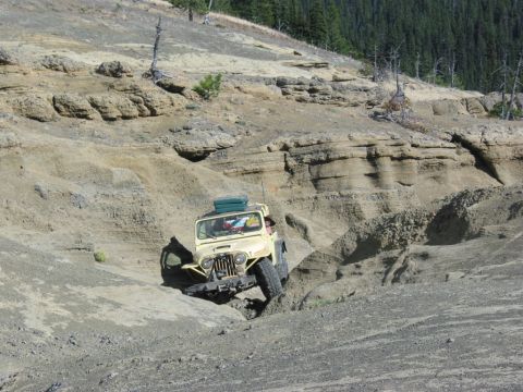 1982 Ford Customline - A yellow Jeep CJ-5 tackles a challenging off-road course, demonstrating its capability in environments.