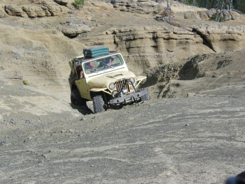 1982 Ford Customline - A yellow Jeep CJ-5 navigates a steep, rocky incline during an off-road excursion.