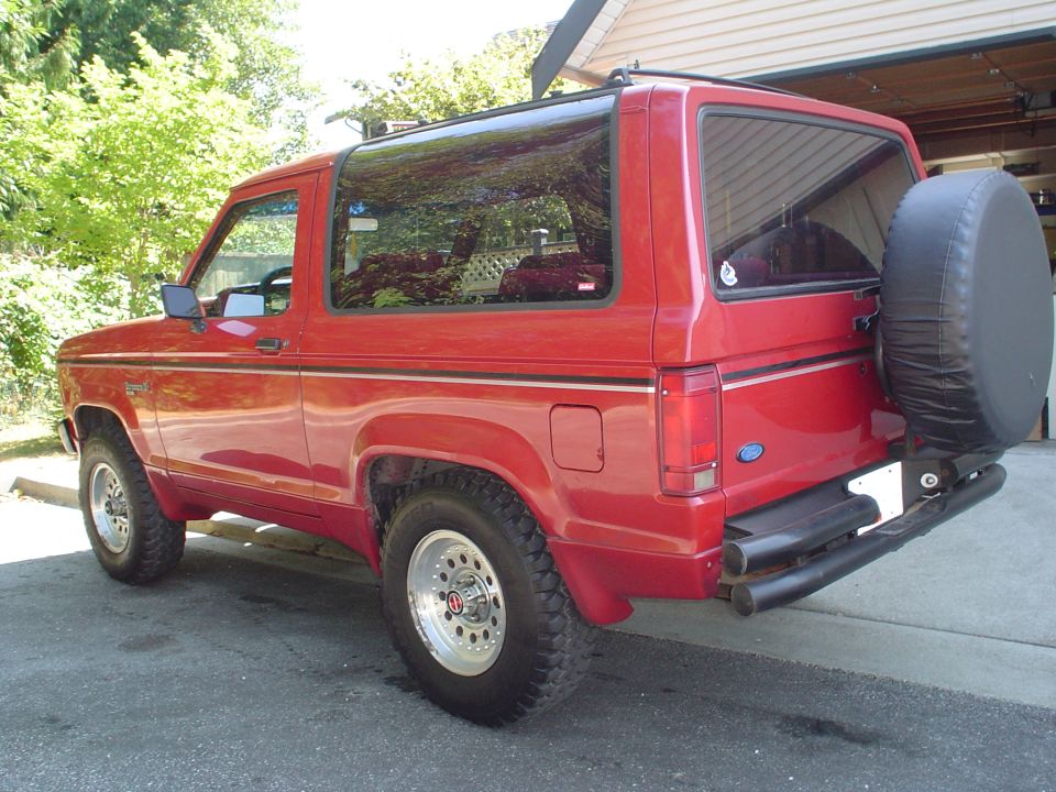 Red 1988 Ford Bronco II rear quarter view with spare tire mounted on rear door