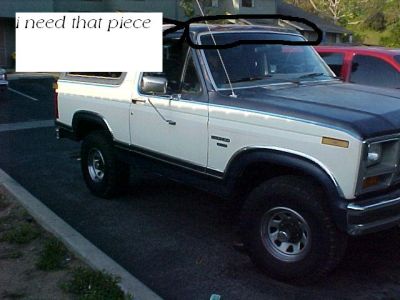 1986 Ford Bronco - A two-tone Ford Bronco is parked next to a red vehicle, with text overlaid on the window.
