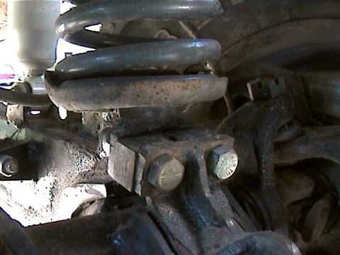 1977 Ford F-150 - This photo shows a close-up of a truck's suspension system, focusing on a coil spring and mounting hardware.