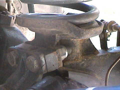 1977 Ford F-150 - A close-up view of a vehicle's suspension system, showing a rusty coil spring mount and bolts.
