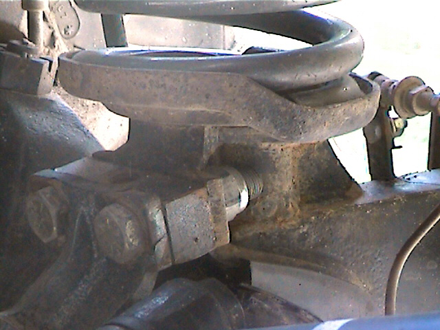 Close-up of a rusty suspension coil spring mount with bolts