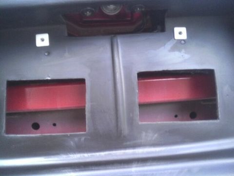 2005 Chevrolet Cavalier - This image shows the rear bumper area of a vehicle, two rectangular cutouts that reveal the red inner structure.