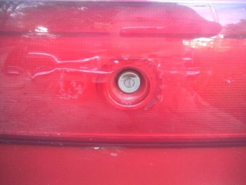 2005 Chevrolet Cavalier - Close-up of the trunk lock cylinder on a red 2005 Chevrolet Cavalier.