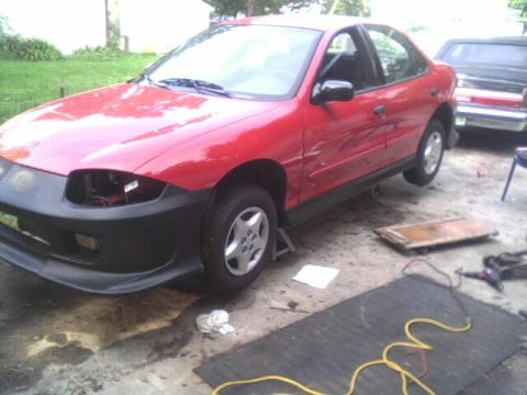 2005 Chevrolet Cavalier - Red 2005 Chevrolet Cavalier sedan undergoing body work, parked on jack stands.