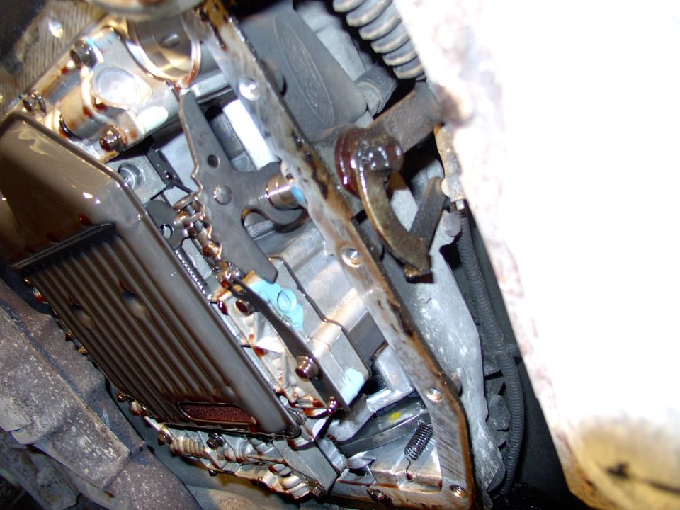 After twisting out about 10 or so bolts with a 10 mm socket, the pan drops and you get your hair washed in ATF. Some of the fluid goes into the drain pan, but most goes on you and the floor. Now you are left looking at the valve body and filter.