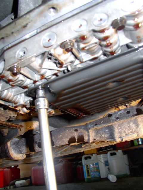 1990 Lincoln Town Car - There's the third and last filter bolt coming off, here's comes some more ATF.