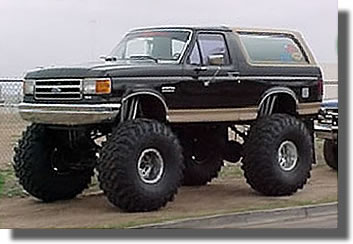 1991 Ford Bronco - This heavily modified Ford Bronco sits high on massive tires, suggesting it's built for off-road adventures.