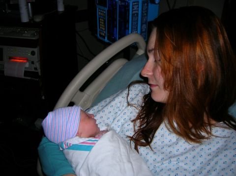 2003 Jeep TJ - A mother gazes at her newborn baby, wrapped in a blanket, in a hospital room.