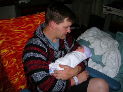 2003 Jeep TJ - A father cradles his newborn child, a tender moment captured shortly after birth.