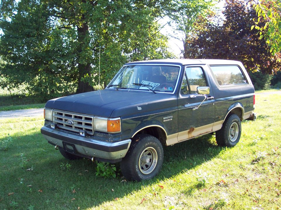 Dark blue 1987 Ford Bronco with tan trim parked on grass
