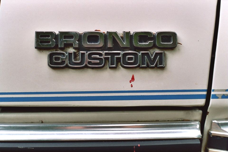 Bronco Custom emblem on white vehicle with blue stripe