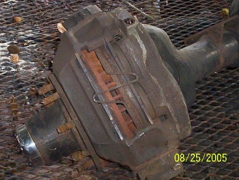 1989 Ford Bronco - A close-up view of a brake caliper and axle assembly, showing signs of rust and wear.