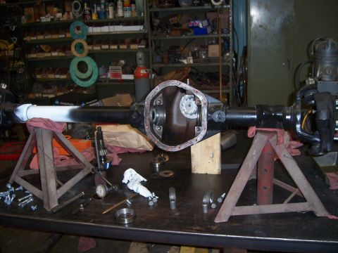 1983 Ford Bronco - A differential axle assembly is disassembled and laid out on a workbench with various tools and parts.