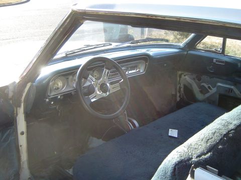 1964 Ford Fairlane - Interior view of a 1964 Ford Fairlane, showing the dashboard, steering wheel, and front bench seat.