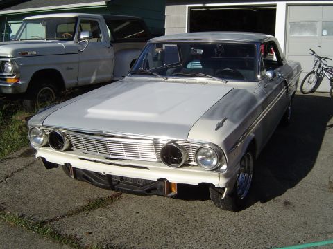 1964 Ford Fairlane - Front view of a 1964 Ford Fairlane, parked in a driveway with a pickup truck and bicycle nearby.