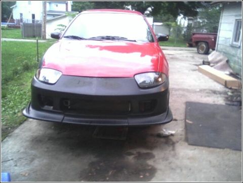 2005 Chevrolet Cavalier - Front view of a red car with a custom black body kit, parked in a driveway.