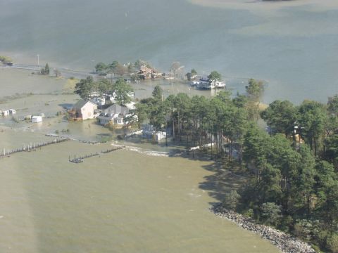 1969 Ford Bronco - Aerial view of a flooded coastal area, showing submerged houses and trees, with a watermark at the bottom right.