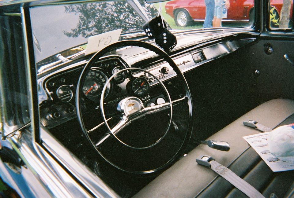 Interior view of a classic car with a large steering wheel and dashboard gauges