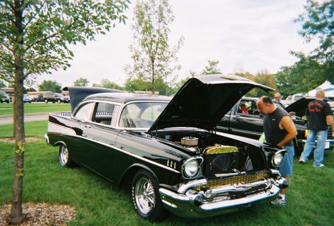 1996 Ford F-150 - Black 1957 Chevrolet Bel Air at a car show, hood open, revealing the engine bay.
