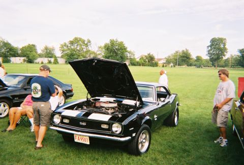 1996 Ford F-150 - Black 1968 Chevrolet Camaro SS at a car show, hood open, with spectators nearby.
