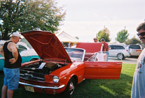 1996 Ford F-150 - A red 1965 Ford Mustang convertible is displayed with its hood and door open at an outdoor event.