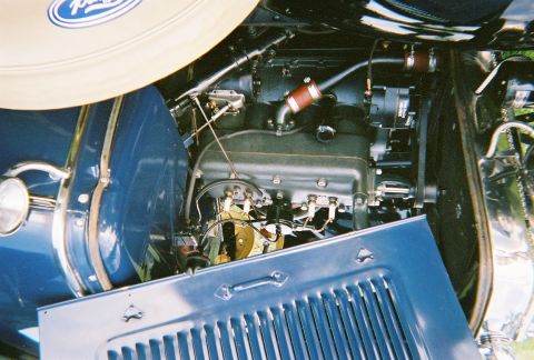 1996 Ford F-150 - The engine compartment of an older vehicle is visible, with various mechanical components and blue body panels.