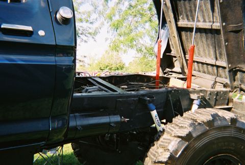 1996 Ford F-150 - The dump bed hydraulics and heavy-duty tires are visible on this truck's chassis.