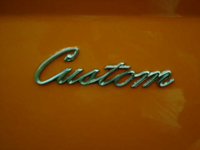 Chrome script Custom emblem mounted on orange painted sheet metal