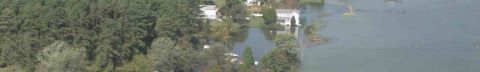 1969 Ford Bronco - Aerial view of a flooded landscape with houses and trees submerged in water.