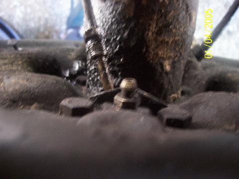 1987 Ford Bronco - From the rear of the backing plate. Brake line is disconected, The two bolts are removed next.