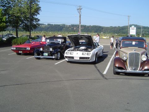 1964 Ford Fairlane - A white Pontiac Firebird is parked with its hood open, alongside other classic cars.