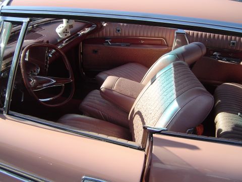 1964 Ford Fairlane - Interior view of a vintage car showing the seats, steering wheel, and dice hanging from the mirror.
