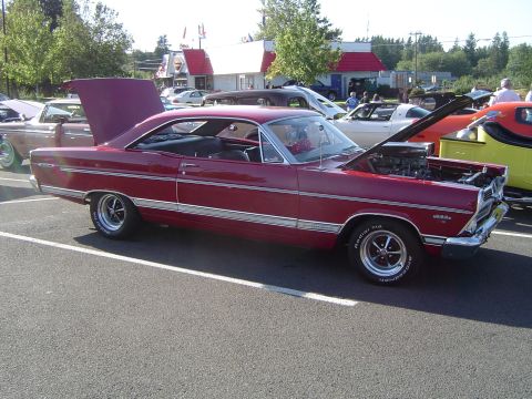 1964 Ford Fairlane - A red coupe sits in a parking lot with its hood and trunk open, revealing the engine and interior.