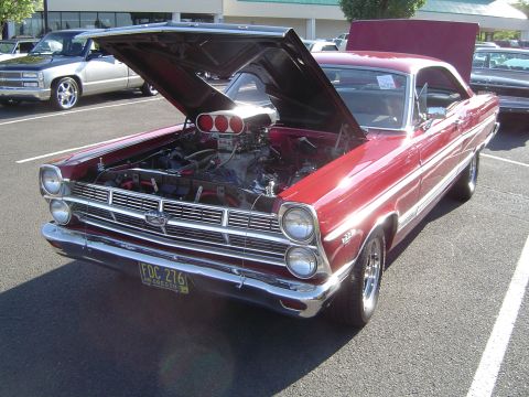 1964 Ford Fairlane - A customized 1966 Ford Fairlane GT coupe is displayed with its hood open, revealing a powerful engine.