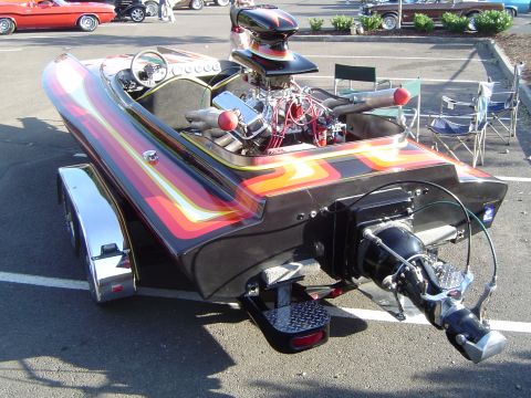 1964 Ford Fairlane - A custom boat with a powerful engine and vibrant flame graphics is displayed on its trailer.