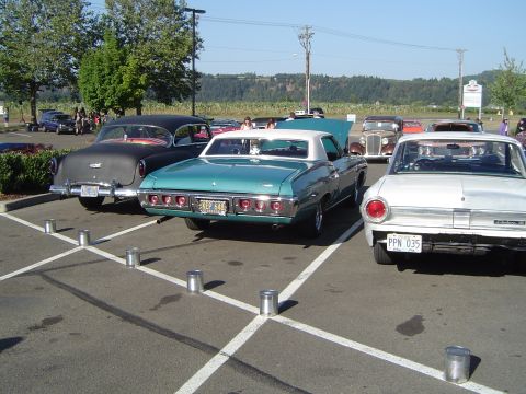 1964 Ford Fairlane - White 1964 Ford Falcon and teal 1969 Chevrolet Impala at a car show.