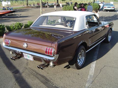 1964 Ford Fairlane - Rear view of a brown 1965 Ford Mustang coupe parked in a lot.