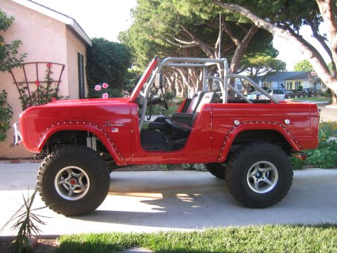 1969 Ford Bronco - This red 1969 Ford Bronco features a roll cage and is shown from the side.