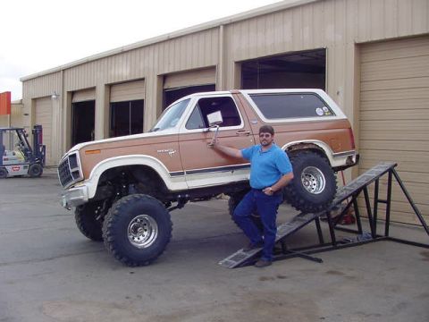 1981 Ford Bronco - A man poses with his lifted Ford Bronco, which appears to be from the early 1980s, in front of a garage.
