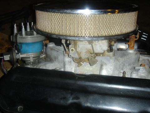 1986 Ford Mustang - Close-up view of an engine's carburetor and air filter assembly, with visible wiring and distributor.